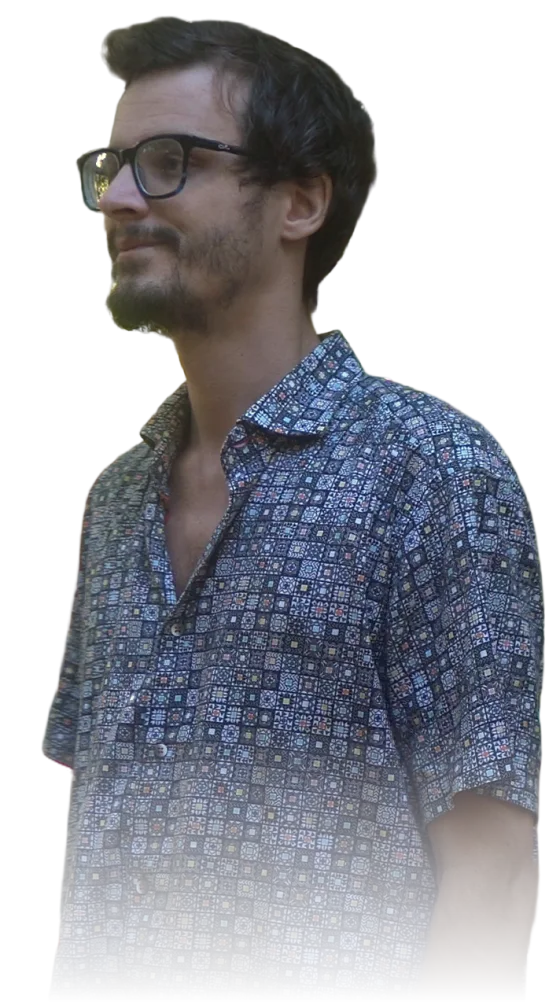 Alek Dumas in profile, smiling, looking toward the words.
