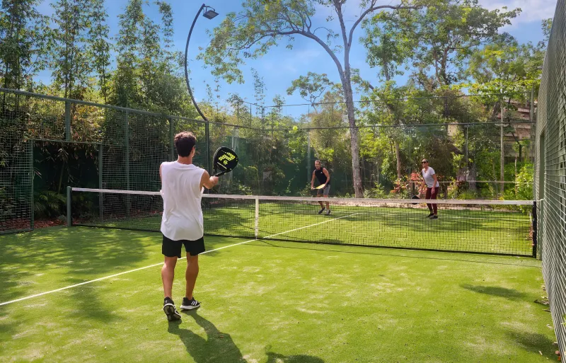 Green padel courts surrounded by jungle.
